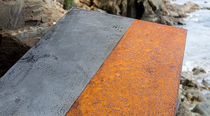 Plancha de metal cuyo lado izquierdo está libre de óxido, mientras que el derecho está todavía oxidado